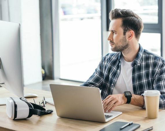 Homem, em um computador portatil, verificando a relação entre uma boa hospedagem e um bom SEO para o seu site