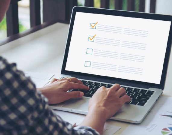 Pessoa de perfil fazendo sua checklist de SEO no computador/laptop.
